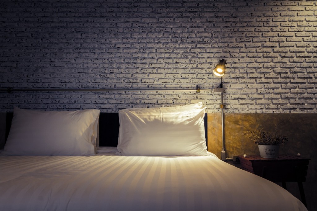 Close up of a bed with lamp light