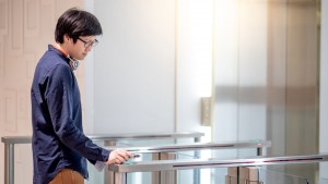 Young Asian business man using smartphone to open automatic gate