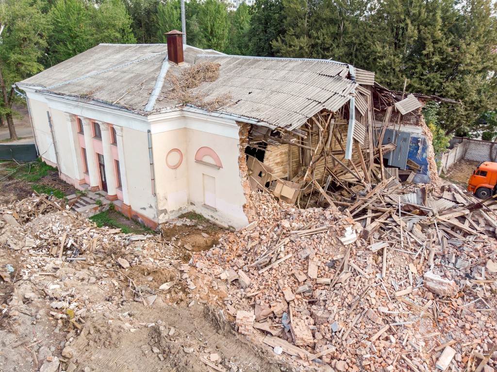 half destroyed brick building at demolition site