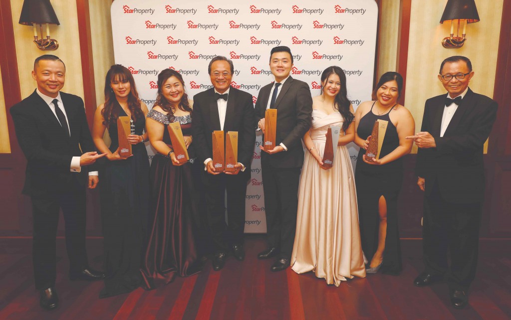 Celebrating their big win, OSK property development chief operating officer Seth Lim Sow Wu (4th from left) takes a group photo with his team holding up their seven trophies as Fu (right) and Yap (left) point to their big haul.