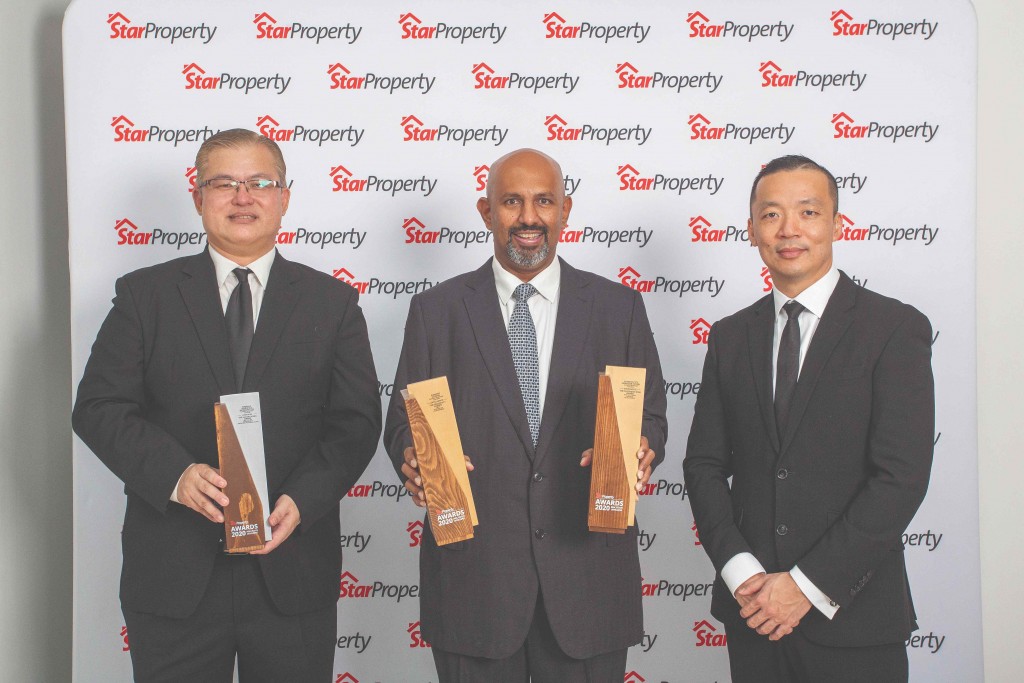 Sunway City Iskandar Puteri CEO Gerard Soosay (centre) and assistant general manager Ng Chai Teck (left) hold up their trophies as Yap looks on.
