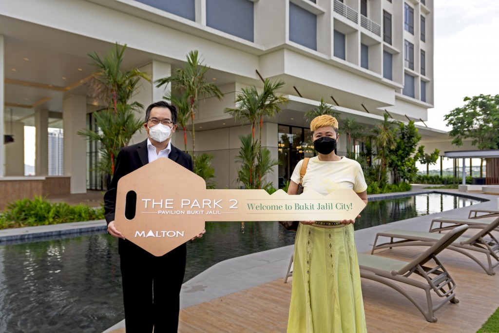 Yuen (right) receiving a mock key to her dream home in The Park 2 from Choo.