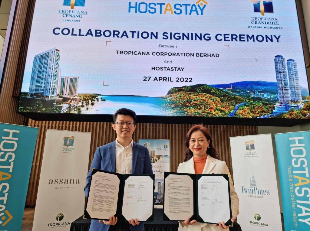 Lee (right) and Oon holding the signed documents.