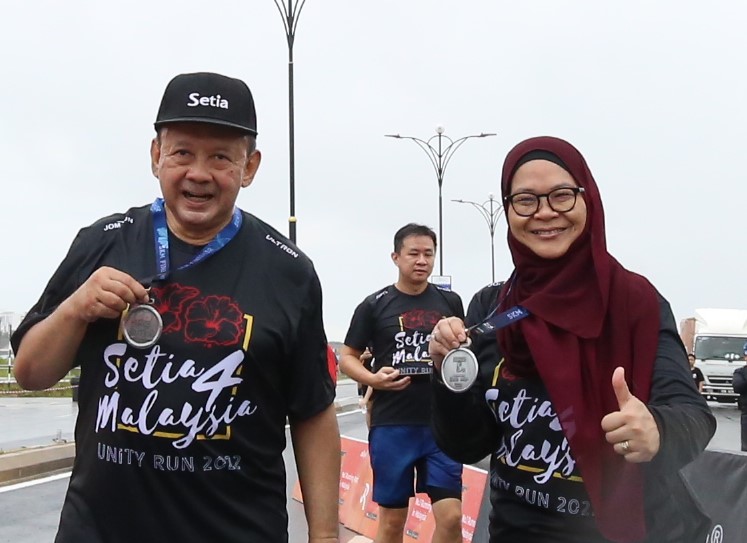 Syed Anwar and Merina show their medals after completing their run.