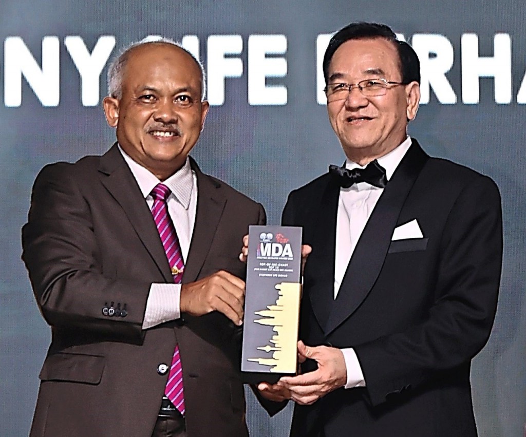 Symphony Life Bhd executive chairman Tan Sri  Tan Khoon Hai receiving his trophy from Noor  Azman. - Art Chen / The Star
