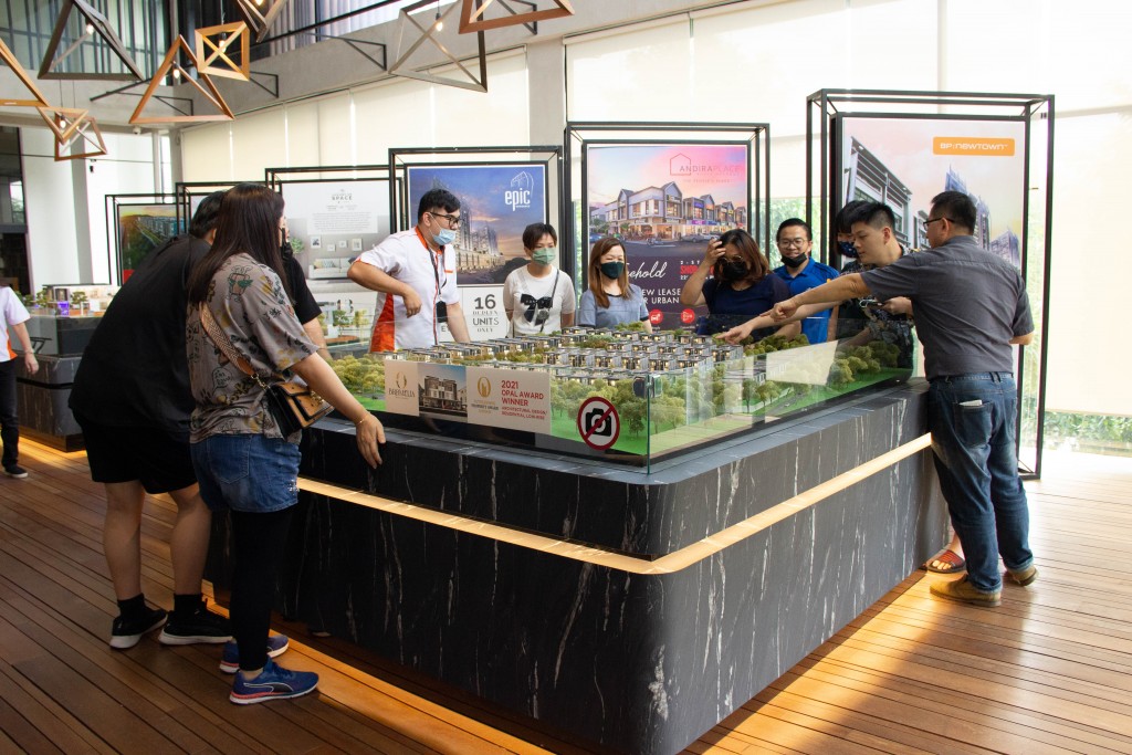 Potential buyers looking at the scale model.