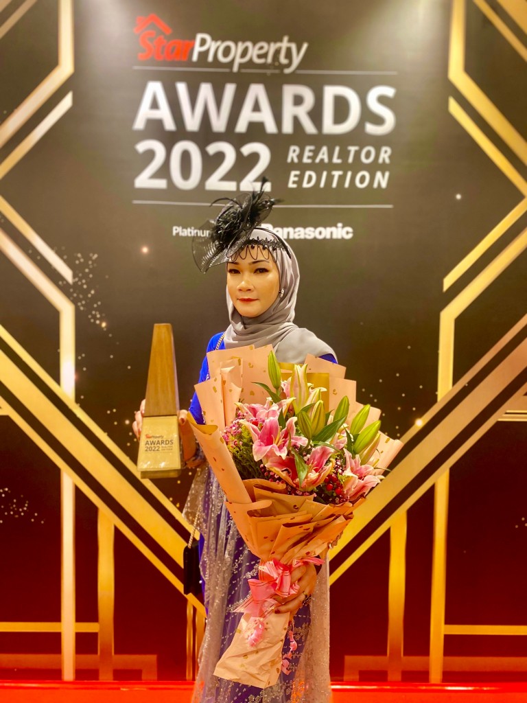 Noorisma Roslan poses with her trophy and bouquet of flowers after winning the Most Exceptional Leader Award for the female category. 