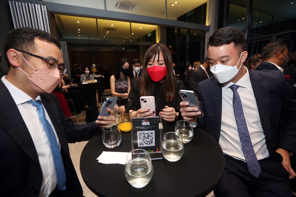 Guests using their mobiles to scan the QR code for the launch countdown.