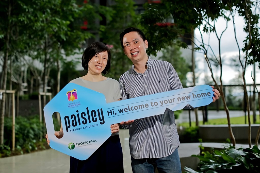 Tai (right) and his wife receiving the mock key to their new home.
