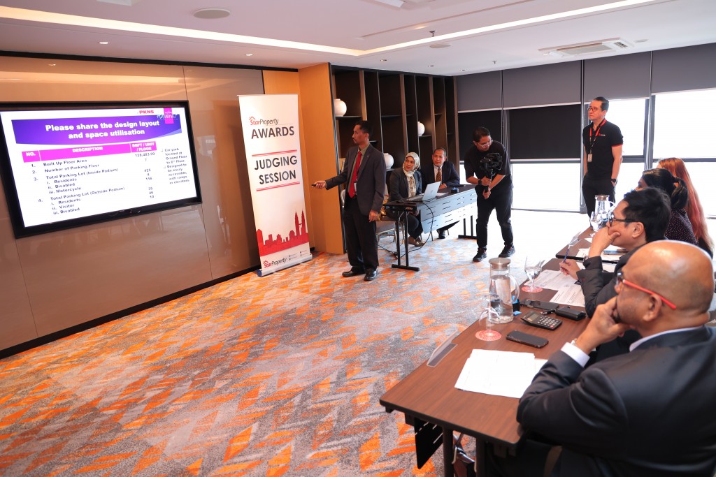 A videographer taking clips of one of the StarProperty Awards 2023 judging sessions as the judges pay attention to the presenter.
