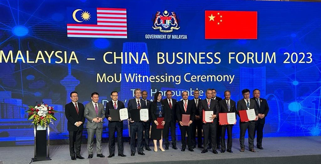 Lim (fourth from left), along with business members, posing for a group photo with Anwar (seventh from left) and Malaysian cabinet ministers after the signing ceremony.