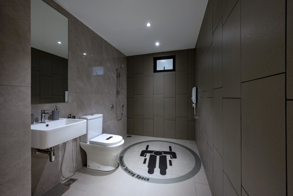 The spacious bathroom allows for easy wheelchair access and is stylishly designed with full-height wall tiles.