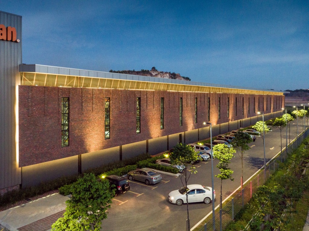The suspended brick wall serves as both a wind funnel and heat trap for the warehouse, and has narrow and thin windows to reduce heat penetration.