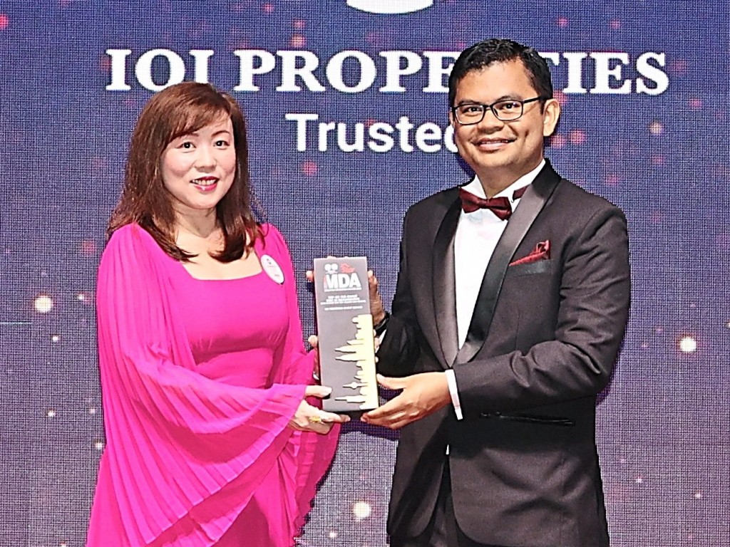 IOI Properties Group chief financial officer Melissa Tan (left) receiving the trophy from Akmal Nasrullah.