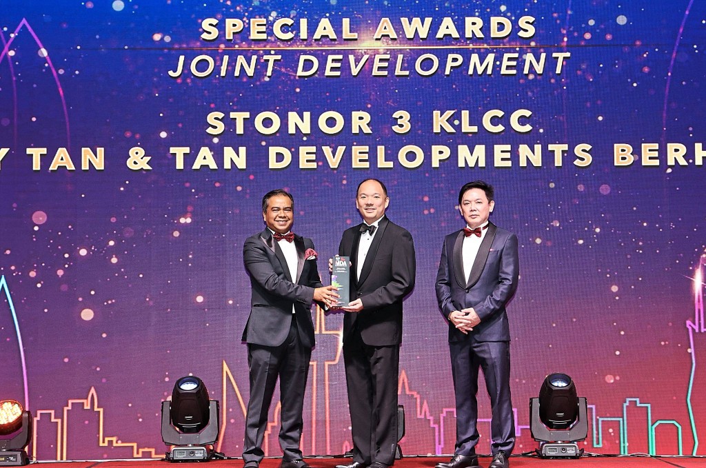 Tan & Tan Developments chief executive officer Tan Yee Seng receiving the trophy from Firdaus.