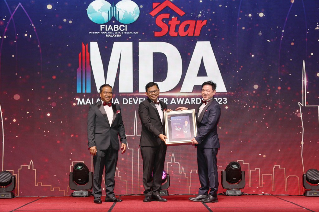 Akmal Nasrullah receiving a souvenir from Yeow (right) as Firdaus (left) looks on.