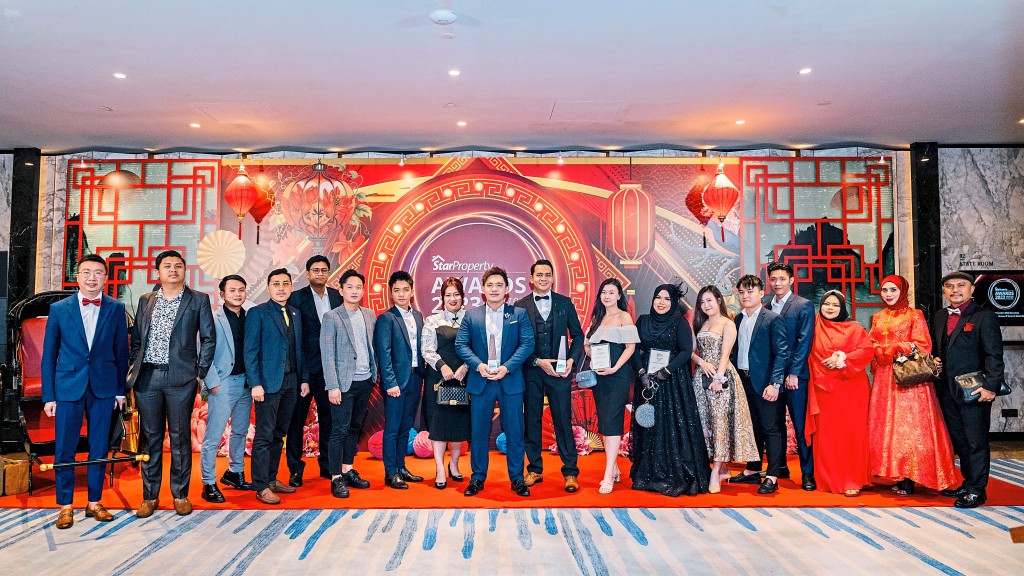 The Maxxan Realty team takes a group photo with the trophies that they won.