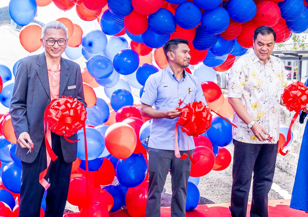 Cutting the ribbon (from left) are Ong,Mohd Fareez and Johan.