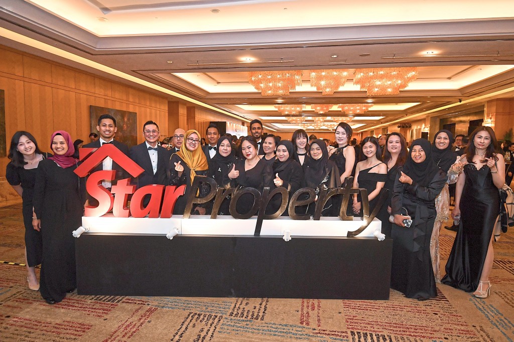 The UEM Sunrise crew took advantage of the StarProperty signage for a memorable snapshot. — IZZRAFIQ ALIAS/The Star