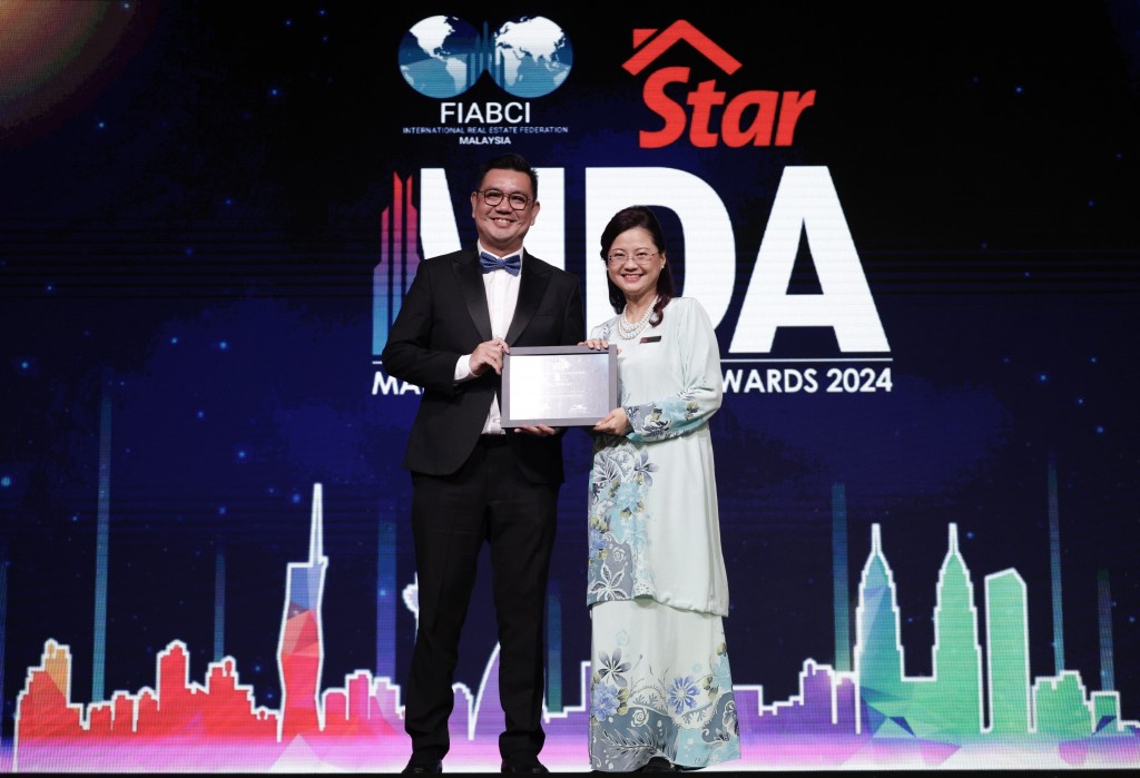 UAC Bhd national sales manager Henry Choo (left) receiving a certificate of appreciation from Wang. — FAIHAN GHANI/The Star