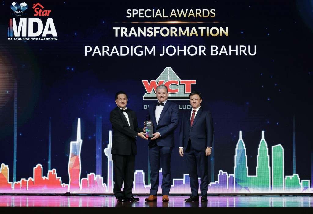 WCT Land Sdn Bhd property developement chief operating officer Chong Wah Hing (centre) receiving the trophy from Yu (left) as Chan looks o