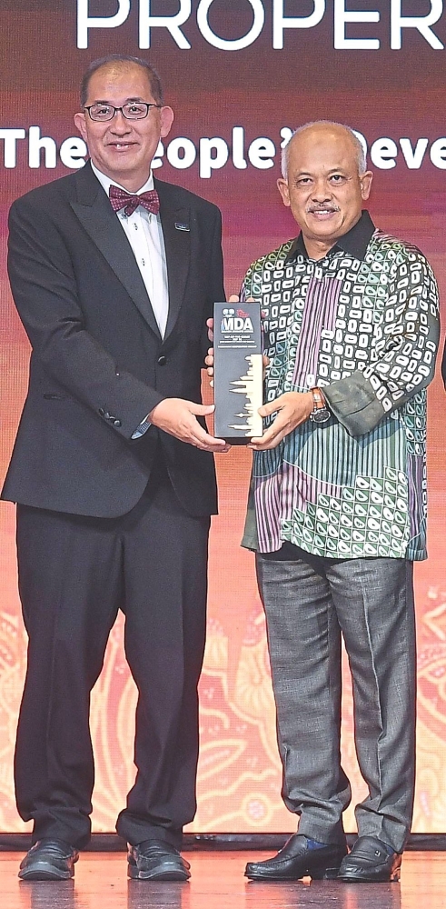 Paramount Corporation Bhd deputy group chief executive officer Beh Chun Chong (left) receiving the MDA 2025 trophy from Housing and Local Government Ministry secretary-general Datuk Wira M Noor Azman Taib.